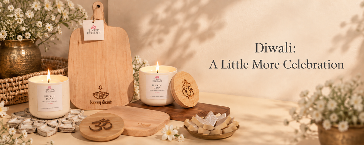 A styled product display for Happy Dripping Candle Co. featuring a wooden cutting board engraved with a diya, two white candles, wooden coasters, and small wooden sweets on a warm beige background with the text 'Diwali: A Little More Celebration'.