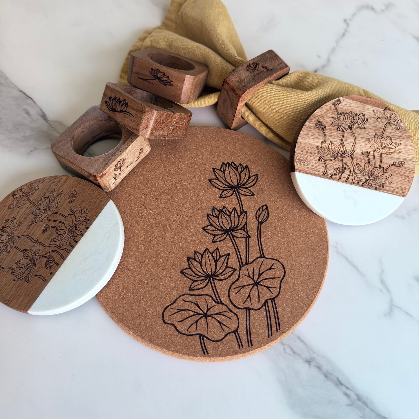Set of wooden coasters with lotus designs on a marble surface